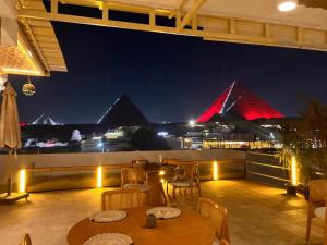 カイロにあるPyramids Top view innの- パティオ(ピラミッド付きの夜のテーブルと椅子付)