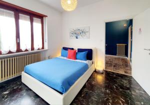 AlmeseにあるFiori e Frutti Guest Homeのベッドルーム1室(青と赤の枕が備わるベッド1台付)