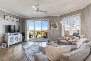a living room with a couch and a tv at Enjoy Oceanfront Luxury and Magical Sunrises at this 2-bedroom 2-bath condo in Amelia Island