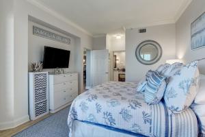 a bedroom with a bed and a flat screen tv at Enjoy Oceanfront Luxury and Magical Sunrises at this 2-bedroom 2-bath condo in Amelia Island +31 photos