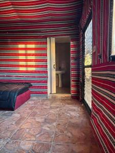 Habitación con una pared de rayas rojas y blancas en Dana Sunset camp, en Nijil