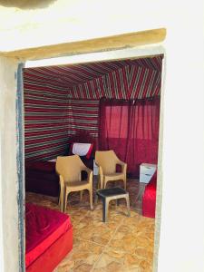 Una sala de estar con dos sillas y una cama. en Dana Sunset camp, en Nijil