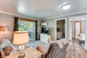una sala de estar con un sofá y una mesa en Wayland Retreat with Deck Walk to Downtown!, en Wayland