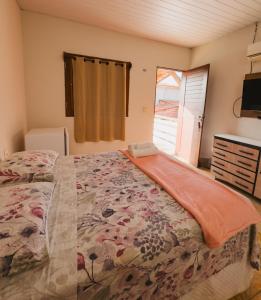 a bedroom with a bed with a dresser and a window at Pousada Recanto dos Ventos in Icaraí
