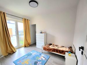 a bedroom with a bed and a dresser and a window at Modern 2023 apartment in Kutno