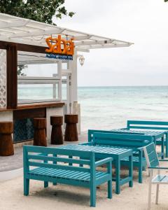 a group of blue benches on the beach at Endorphins Beach Villa in Dhiffushi
