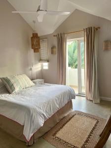 a bedroom with a bed and a large window at Luna Park no 4 in Grand Baie