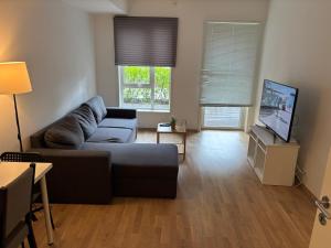 a living room with a couch and a flat screen tv at One Bedroom Apartment Central Jessheim in Jessheim