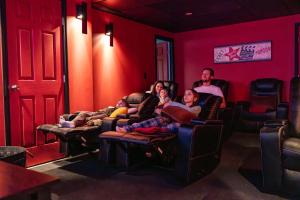 a group of people sitting on couches in a red room at The Poconest - Luxurious Mountain Mansion in Long Pond