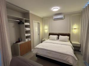 a bedroom with a bed and a book shelf at Ravello Residencial, Perto do Centro e da Ponte da Amizade in Foz do Iguaçu