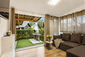 a living room with a couch and a large window at Superior Holiday Home Fortuna in Čatež ob Savi