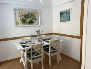 a white dining room with a white table and chairs at Mar y Sol Almuñécar Apartment in Almuñécar