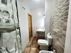 a bathroom with a toilet and a sink and a mirror at Mar y Sol Almuñécar Apartment in Almuñécar