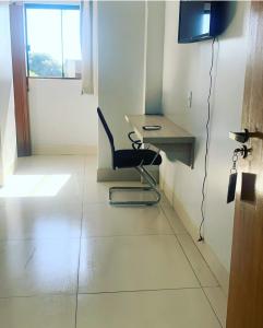 een kamer met een stoel, een bureau en een televisie bij Hotel Rio do Ouro in Porangatu +13 foto's