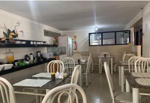 a kitchen with a table and chairs in a room at Hotel Rio do Ouro in Porangatu