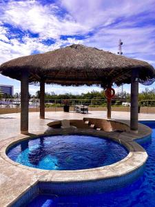 Un grand parasol est installé à côté de la piscine. dans l'établissement 12th Floor CViews Andamar Walking Beach, à Cedro