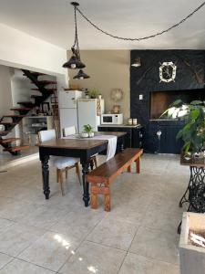 a dining room with a table and a bench at TANTI casa con pileta in Cordoba