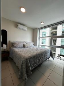une chambre avec un lit et une grande fenêtre dans l'établissement 12th Floor CViews Andamar Walking Beach, à Cedro