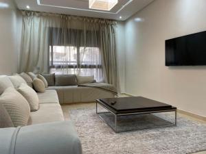 a living room with a white couch and a coffee table at Appartement Le Guéliz,au centre de Marrakech, pool & fast WiFi in Marrakech