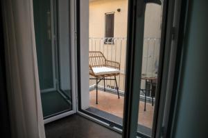 a window with a chair sitting on a balcony at La casa nel vicolo 3 in Giardini Naxos
