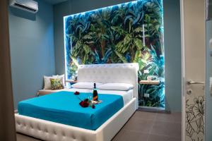 a bedroom with a blue and white bed with a painting at La casa nel vicolo 3 in Giardini Naxos