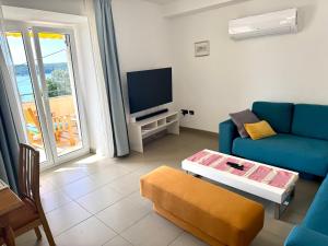 坎普尔Apartments Trlika的客厅里有一张蓝色沙发和一台电视