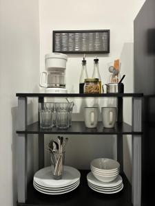 a black shelf with plates and utensils on it at Charming guest studio in the heart of Miami in Miami