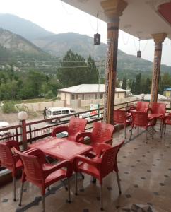 a group of red chairs and tables on a balcony at Balakot International Hotel in Dargai