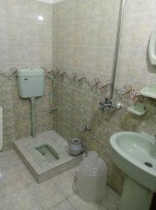 a bathroom with a shower and a sink and a toilet at Balakot International Hotel in Dargai