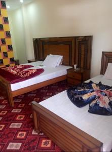 two beds in a hotel room with at Balakot International Hotel in Dargai