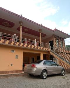 a car parked in front of a house at Balakot International Hotel in Dargai +5 photos