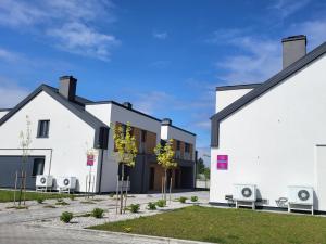 a house with white walls and black roofs at Modern 2023 apartment in Kutno