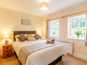Un dormitorio con una cama grande y dos ventanas. en 1 Bed in Pateley Bridge 89152, en Summer Bridge