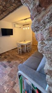 a dining room with a table and a stone wall at Sa meraviglia in Posada +42 photos