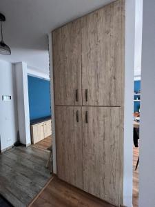 a room with a large wooden cabinet in a room at Timeless Comfort in Sfântu-Gheorghe