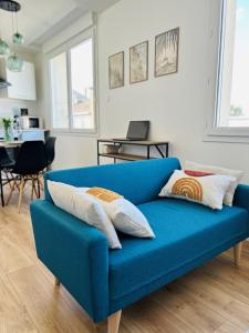 - un canapé bleu dans le salon dans l'établissement Appartement proche Ancenis - Loire et Vélo, à Liré