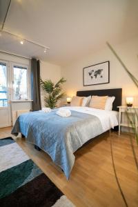a bedroom with a large bed with a blue blanket at Earth-Toned Studio, Near Haga & Järntorget in Gothenburg