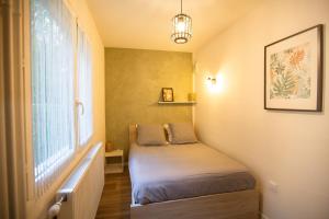a small bed in a small room with a window at Vercors et Vous in Saint-Jean-en-Royans