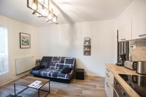 a living room with a couch in the corner of a room at Vercors et Vous in Saint-Jean-en-Royans
