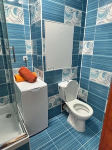 a blue tiled bathroom with a toilet and a shower at SimpleStay with parking in Košice