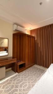 a bedroom with a bed and a desk and a mirror at نصف القمر للشقق المخدومة in Ḩaql +29 photos