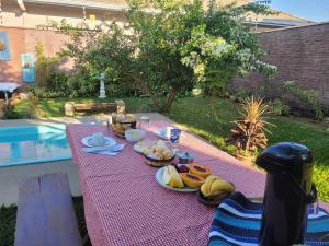 ein Picknicktisch mit Essen darauf neben einem Pool in der Unterkunft Pousada Canto das Estrelas in Chapada dos Guimarães