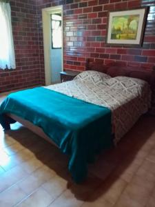 a bedroom with a bed in a brick wall at Casa com piscina Itapeva Torres in Torres +25 photos