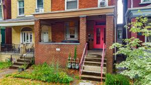 a brick house with a red door and stairs at Steps Away From Hospital - 2 Queen Bed - City View in Pittsburgh