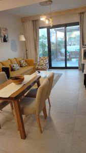 a living room with couches and a table and chairs at ElGouna, Elegant 1Bedroom, private patio in Fanadir Marina in Hurghada