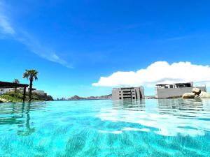 a large pool of water with buildings in the background at Beachfront luxury Condo w Pool in Cabo San Lucas