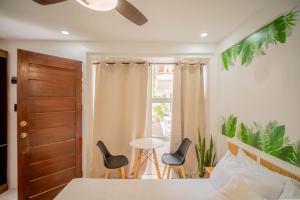 a bedroom with a bed with two chairs and a table at Hayya Hayya Villas in Ocoy
