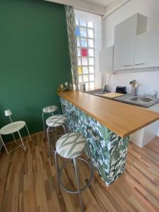 a kitchen with a counter and stools in a room at Studio Cleo - ein Raum - Dusche und WC extern am Flur in Pörtschach am Wörthersee