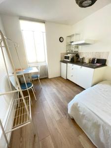 een kamer met een bed en een keuken met een ladder bij Studio au cœur de Chabeuil in Chabeuil