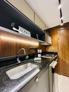 a kitchen with a sink and a stove at Vita Boulevard Gramado in Gramado